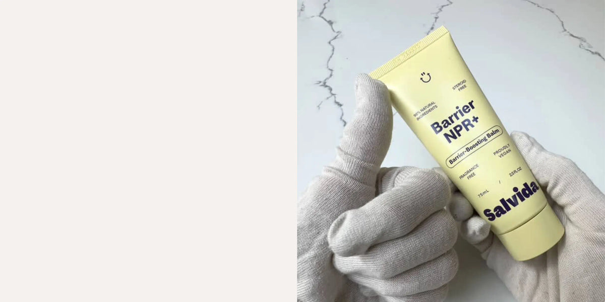 Gloved hand holding a tube of Salvida Barrier NPR+ balm