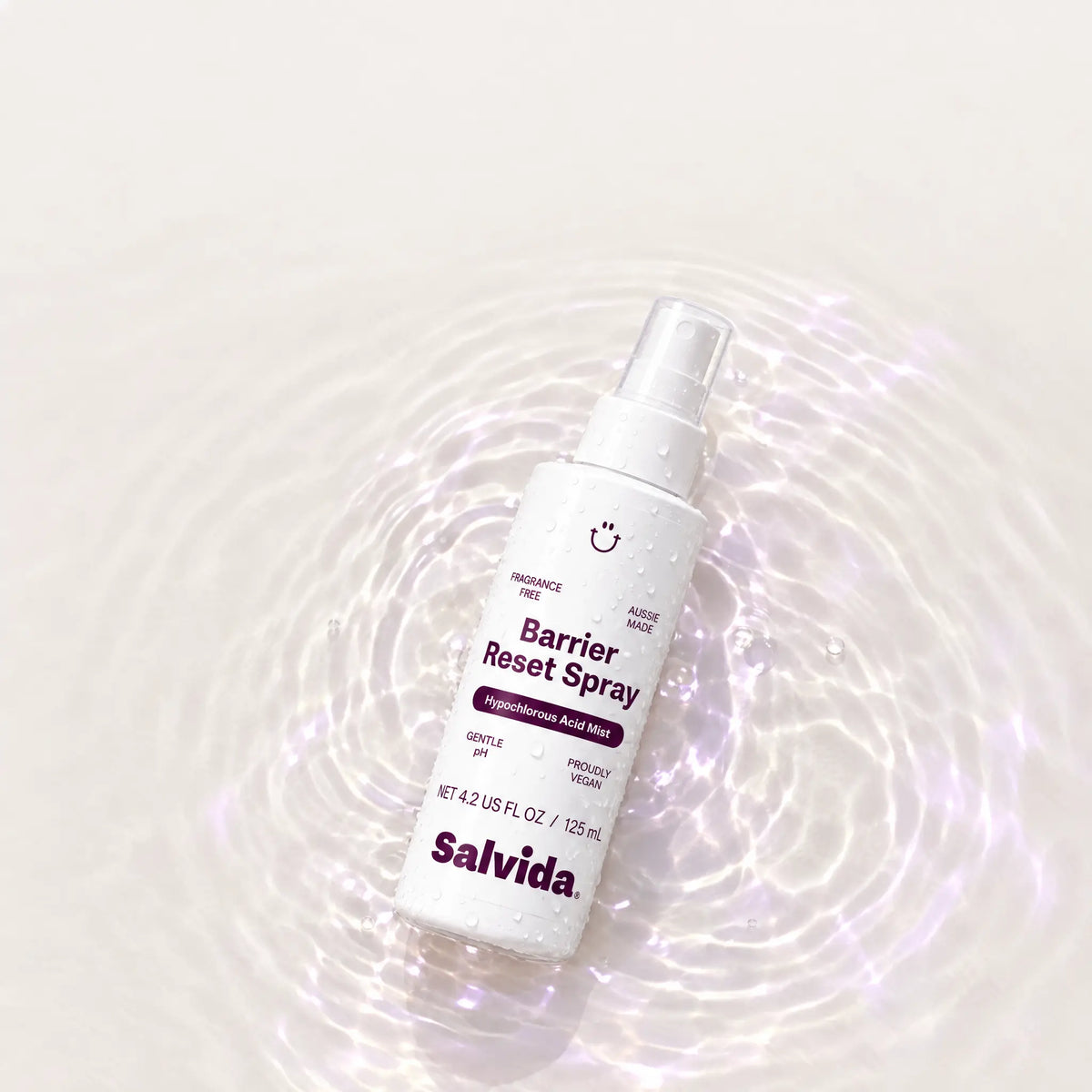 Salvida Barrier Reset Spray bottle lying on a rippling water surface with soft light reflections